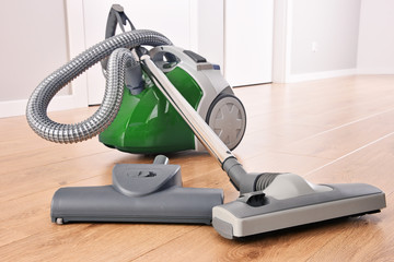 Canister vacuum cleaner for home use on the floor panels