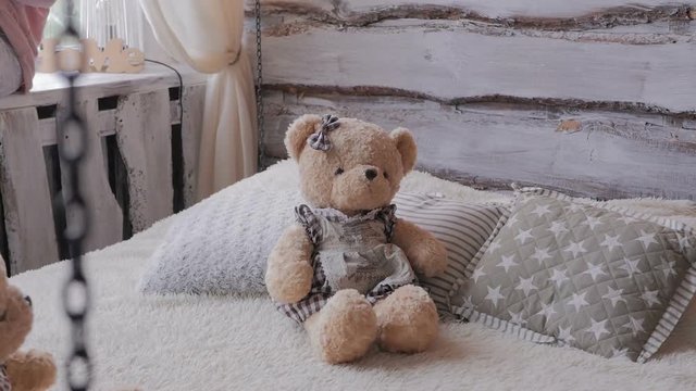 Two cute little brown teddy bear sitting on the bed