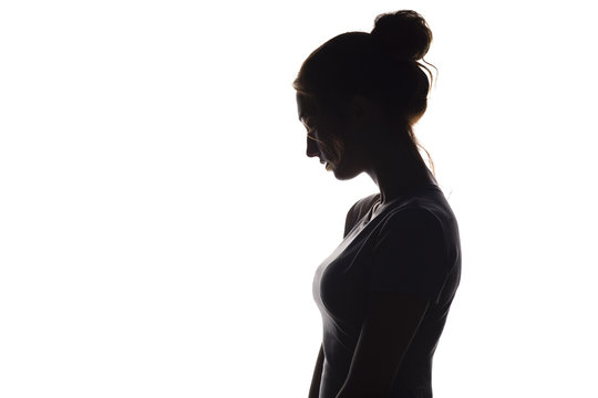 profile silhouette of a pensive girl, a young woman lowered her head down on a white isolated background