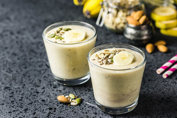 Oats banana almond milk shake with nuts and seeds on dark background. Selective focus, space for text.
