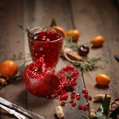 Pomegranate juice with pomegranates and dried fruits on a wooden table. Country style.