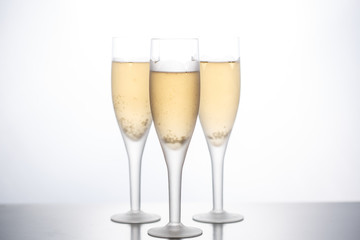 Glasses with champagne empty and filled on a white background.