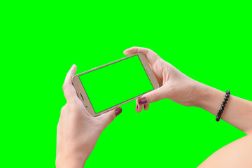 Smart phone in girl hands close-up, isolated in green, chroma key.