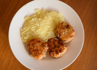 Home made cutlets with mashed potatoes on wooden table.