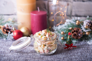 Fototapeta na wymiar Traditional New Year and Christmas Russian salad Olivier (olivie) in a jar. Close-up, selective focus.