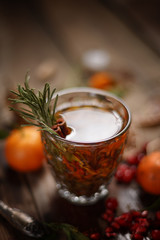 Fragrant fruit tea with tangerines, dried lemons and rosemary on a wooden table. Country style.