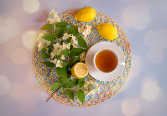 Obraz na płótnie Canvas Green tea, lemons and jasmine flowers on blue background. Top view.