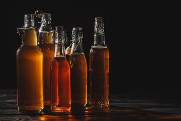 homemade traditional tea in glass bottles isolated on black