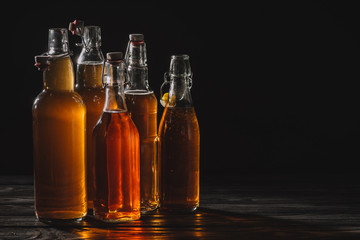 homemade organic tea in glass bottles isolated on black