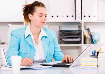 Businesswoman is working with documents and laptop