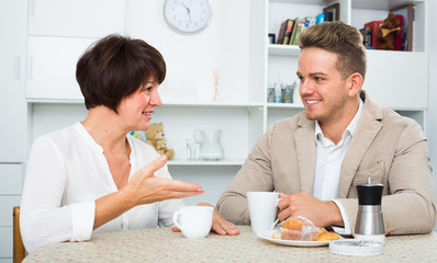 woman and man drinking tea with cakes