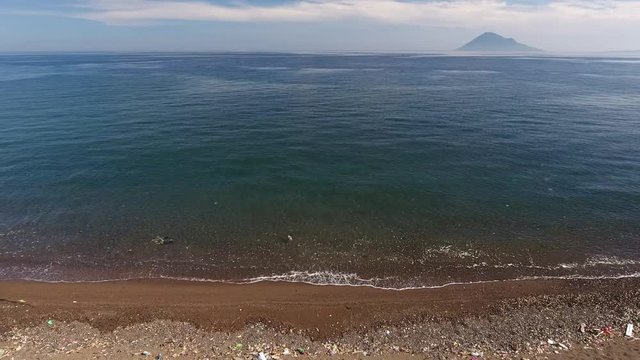 Aerial shot of beach covered in plastic pollution