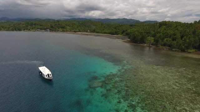 Aerial shot of boat near island in Indonesia