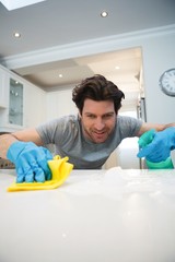 Man cleaning kitchen worktop at home