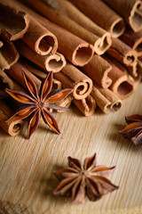  shelves of cinnamon and anise stars in dark backgrounds on a wooden background