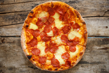 Top view of pizza pepperoni on wooden background