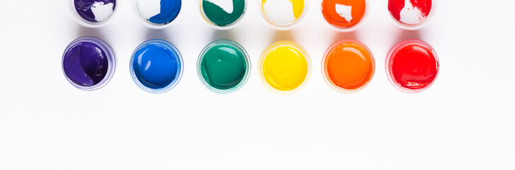 Multicolored gouache on a white background Isolated Paints in containers Top view Copy space Banner Horizontal