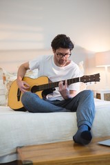 Man playing guitar in bedroom