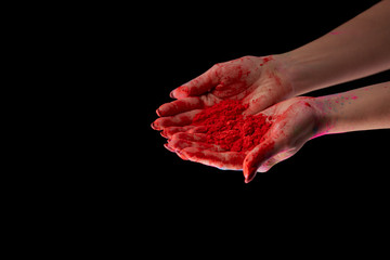 cropped view of adult woman holding red holi powder isolated on black