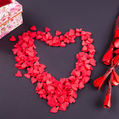 Obraz premium Symbol heart of candy sweets on black background. Top view.