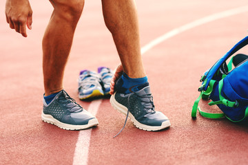Close up of man putting on sneaker before training.