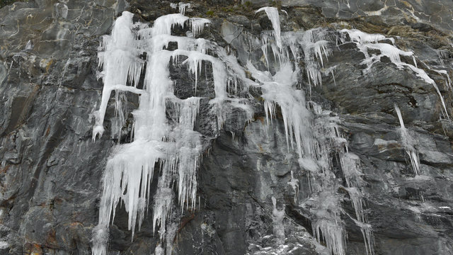 Neve ghiacciata che pende dalla montagna, in ghiaccioli lunghi