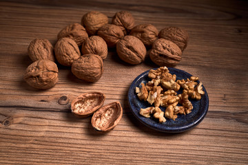 group of tasty nuts next to a bowl on an old wooden board
