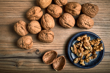 group of tasty nuts next to a bowl on an old wooden board
