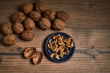 group of tasty nuts next to a bowl on an old wooden board
