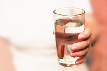 glass of water in the hands of my grandmother, old hands hold a glass of water