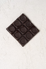 overhead view of dark chocolate pieces on rustic white background