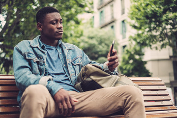 Obraz premium Young african-american with mobile phone outdoors