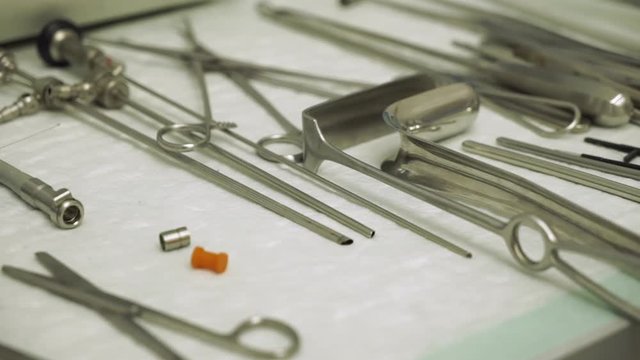 closeup assortment of modern sterile surgical tools on metal tray in operating room at clinic
