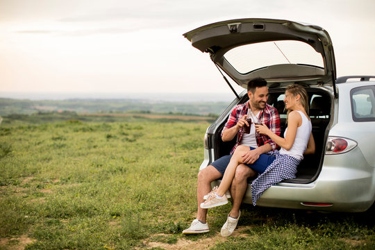 Loving couple sitting in the car trank