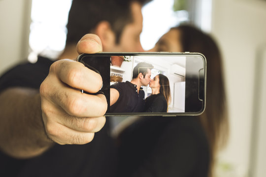 Couple making a selfi kissing and smiling. Love and romance between man and woman