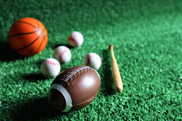 collection of several sport game balls such as football, soccer, and tennis, flying on a green background.