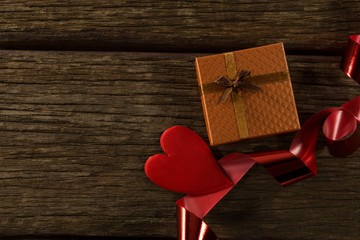 Heart shape decorations and gift on wooden plank