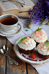 Chocolate cupcake with vanilla cream and strawberries. Vintage style.