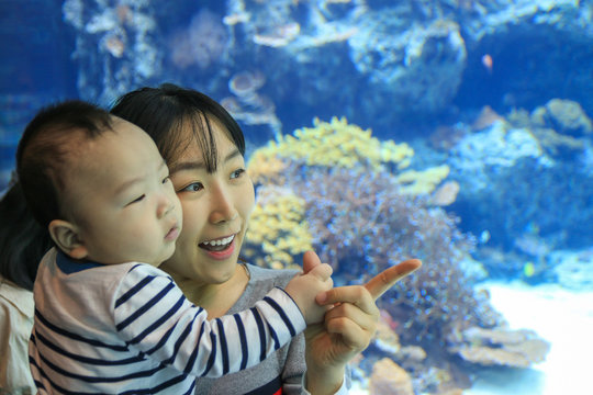 Asian young mother and her son enjoying aquarium.