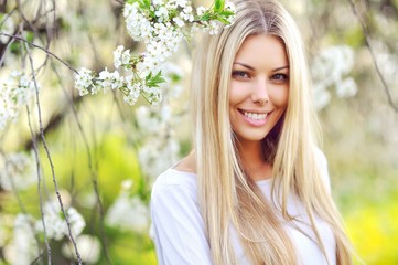 Face of a beautful young blodne woman in a green park - close up