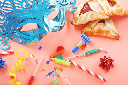 Purim background with carnival mask, party costume and hamantaschen cookies.