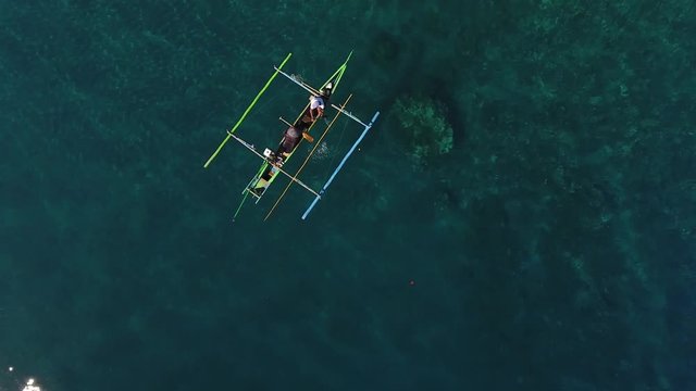 Fisherman fishing on coral reef in boat from drone