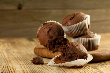 Chocolate muffin, homemade pastry on a wooden background close-up in rustic style