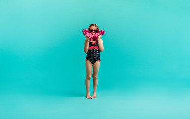 Girl in swimwear with two pink pineapples