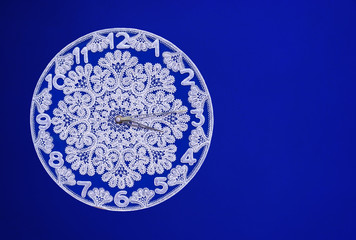 White lace clock on a blue background.