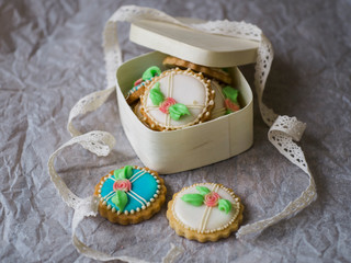 Fototapeta na wymiar Box with blue and white Cookies decorated with flowers in vintage style on white background for Valentine's Day. Present for Women's Day or Mother's Day. Top view.