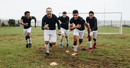 Football players celebrating victory running on field © Jacob Lund