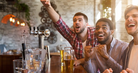 Men cheering for football team in sport bar