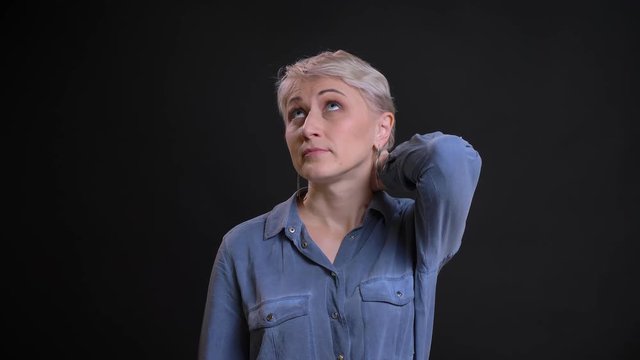 Closeup portrait of thoughtful caucasian woman rubbing her neck being confused or freaked out