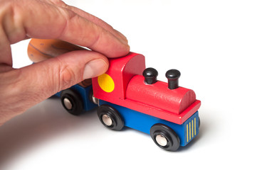closeup of man playing with wooden train toy on white background